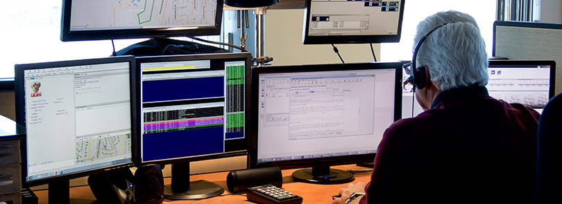 An emergency call taker looking at open Guardian 9-1- 1 Call Handling applications on desktop
